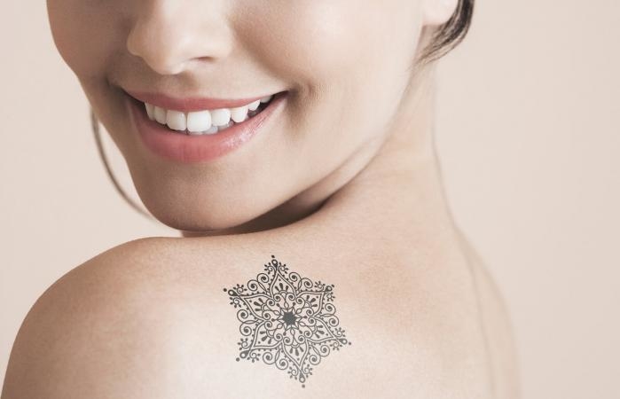 Colorful lower back snowflake tattoos